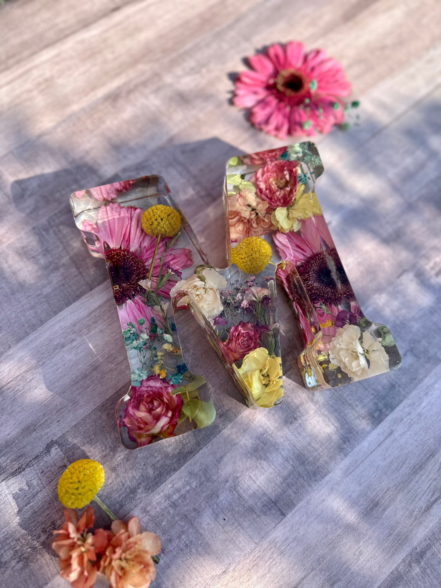 Decorative Resin letter 'M' with floral elements on a textured surface