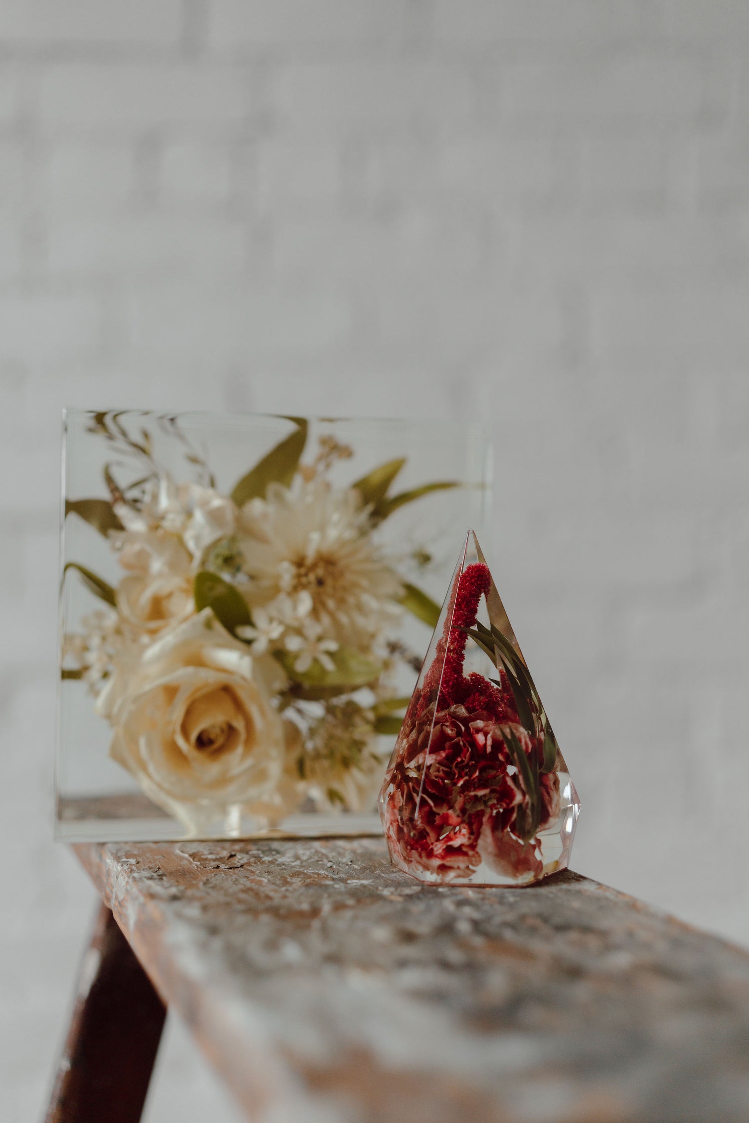 Decorative glass piece with a red interior and floral design on a wooden surface.