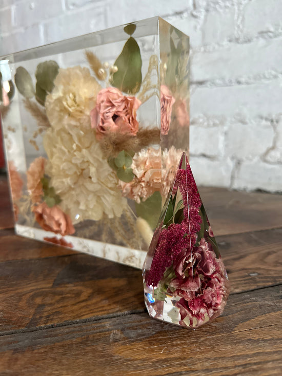 Clear resin block with pressed flowers on a wooden surface