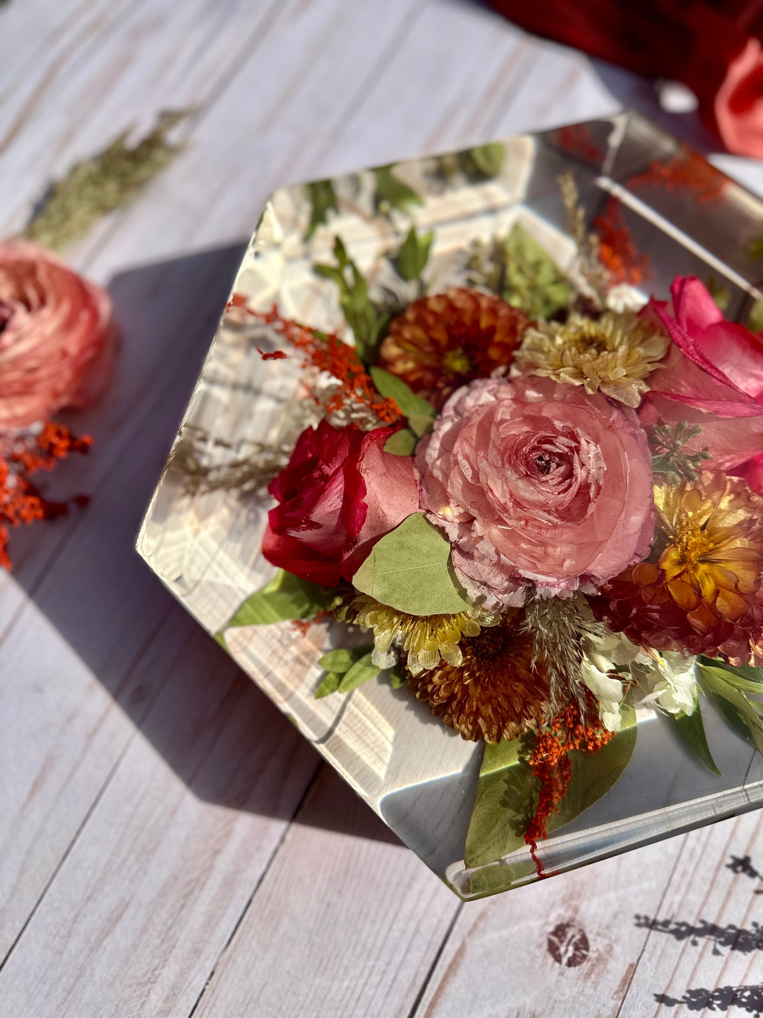 Hexagonal resin floral preserve with flowers on a wooden surface